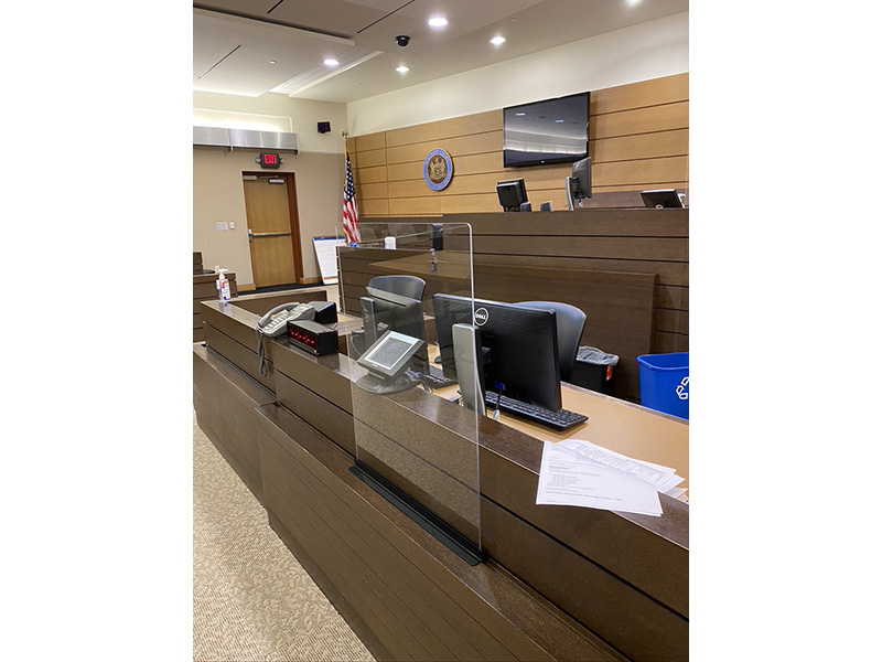 In courtrooms, plastic shields have been placed on the bench, by the judge, and by court clerks and, in some cases, at counsel tables to allow an attorney and his or her client to sit side by sides